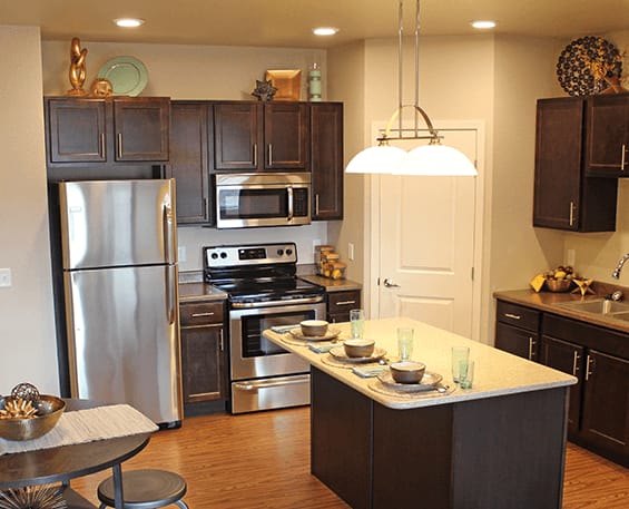 a kitchen with dark wood cabinets and stainless steel appliances