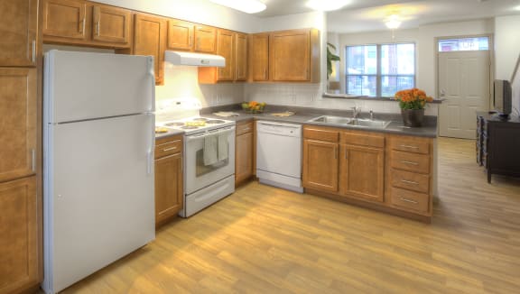 a kitchen with white appliances and wooden cabinets