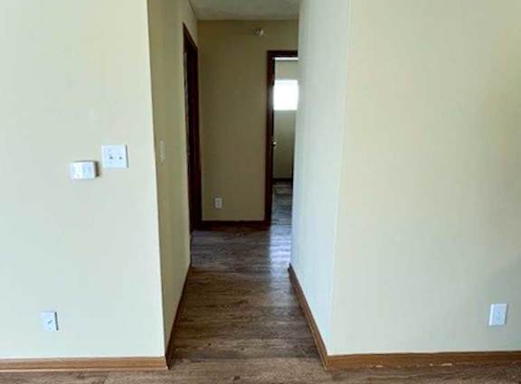 a hallway with wood flooring and white walls
