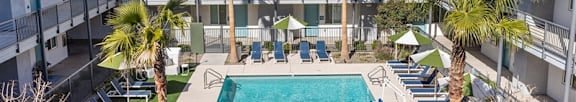 A pool surrounded by palm trees and lounge chairs.at The 89 on Hayden, Scottsdale, AZ 85257