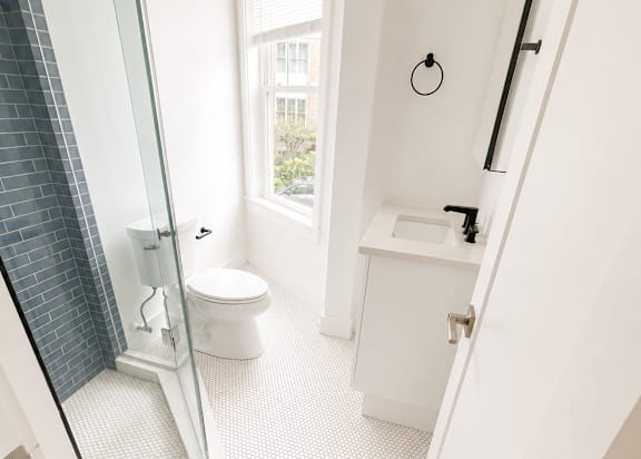 A white bathroom with a walk in shower.