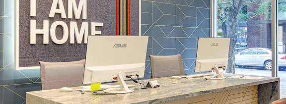 A reception desk with two chairs and a sign that says