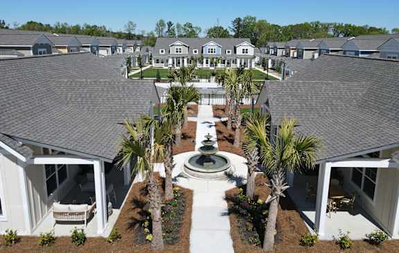 A row of houses with a fountain in the middle of the front yard.