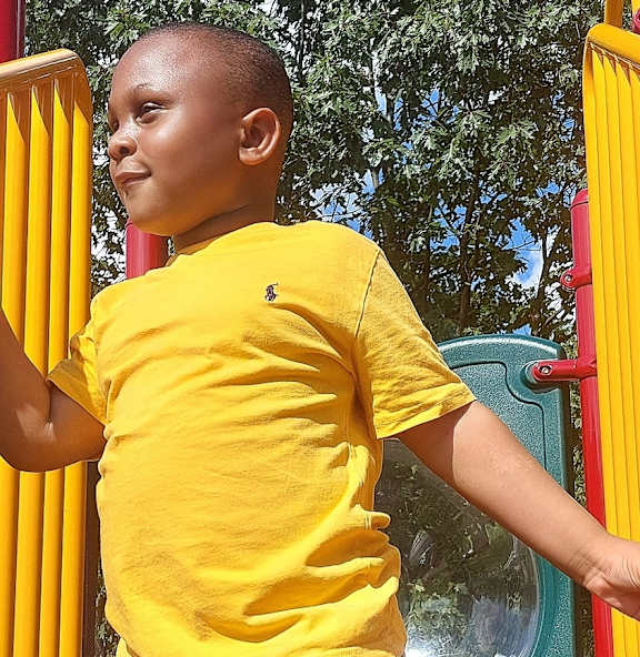 a young boy in a pool with a life jacket