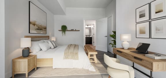 a bedroom with a large bed and a desk with a laptop