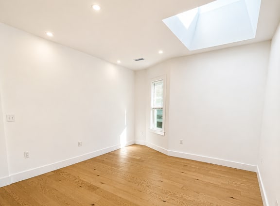 A room with wooden flooring and a skylight.