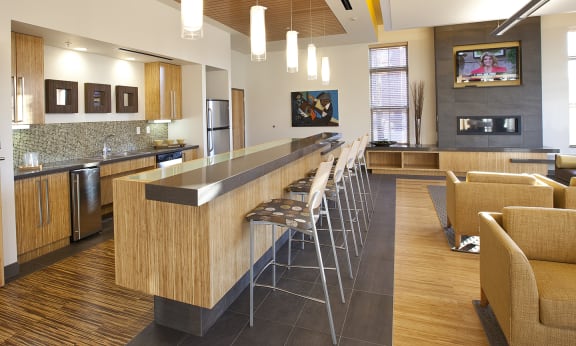 a lobby with a bar and chairs and a kitchen