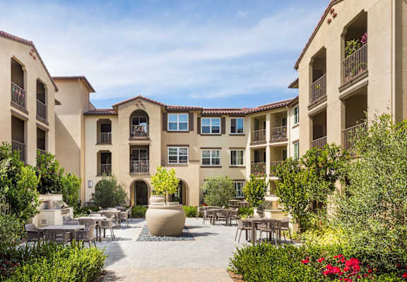 Springville Seniors Apartments community courtyard located in the middle of the community with 2 Bar-B-Ques and tables with chairs