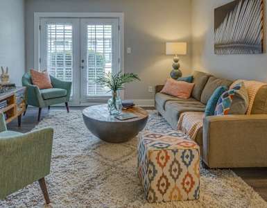 a living room with a couch and chairs and a ceiling fan
