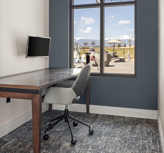 a home office with a desk and a window overlooking a patio at Upland Flats, Colorado, 80922