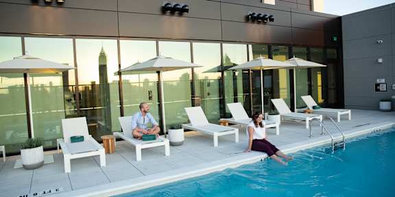 Woman sitting on edge of the pool1 at Scout Living, powered by Placemakr, Atlanta, GA, 30308