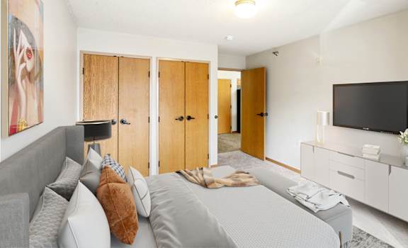 a bedroom with a large bed and a tv on the wall