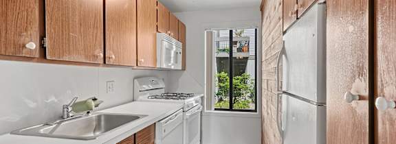 A kitchen with wooden cabinets and white countertops.