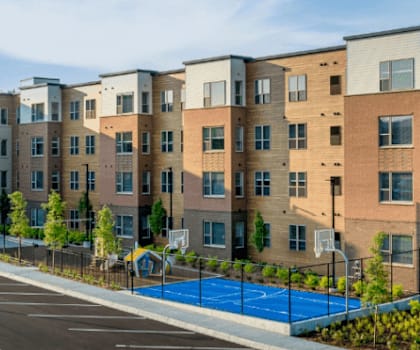 A row of modern apartment buildings with a playground in the foreground.