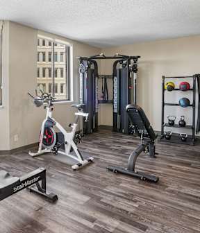 Irvine Park Towers fitness center with strength equipment, stationary bike and city views