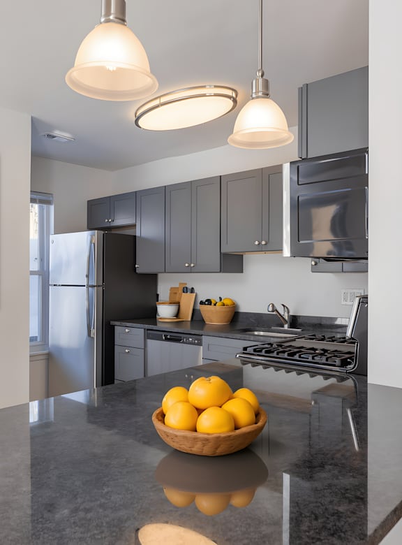 A kitchen with a bowl of lemons on the counter.