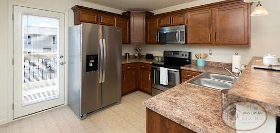 a large kitchen with stainless steel appliances and granite counter tops