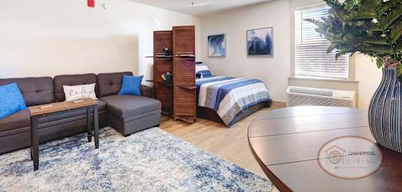 a living room with a couch and a table and a bed