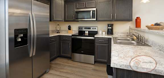 a kitchen with stainless steel appliances and marble counter tops