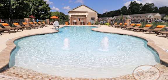 our resort style pool is filled with lounge chairs and water jets