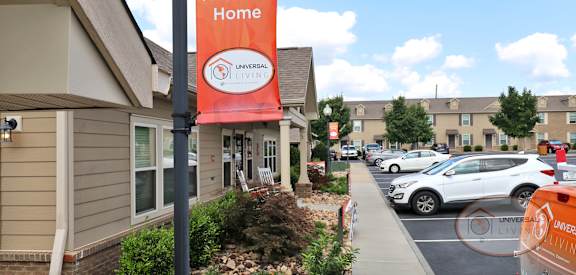 a welcome home sign in front of a building with a parking lot