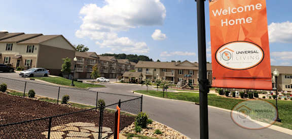 a sign that reads welcome home in front of an apartment building