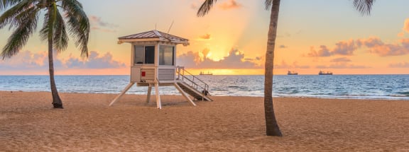 a lifeguard station on the beach at sunset