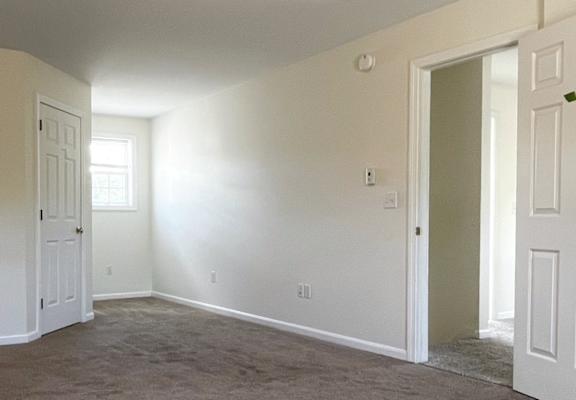 A room with carpeted floor and white walls.