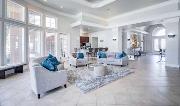 A spacious living room with a grey sofa and a white coffee table.