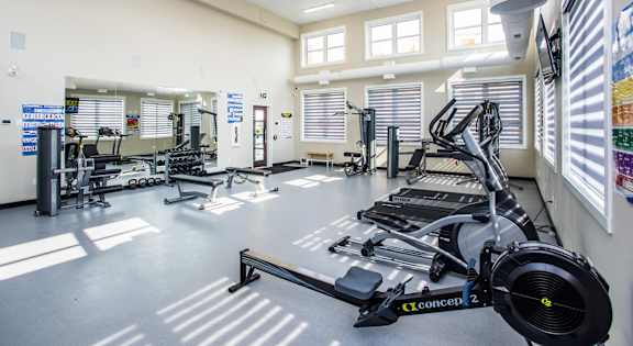 A gym with a treadmill in the foreground.
