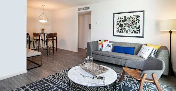 A living room with a grey couch, a coffee table, and a painting on the wall. at Quail Ridge, Plainsboro Township, NJ, 08536