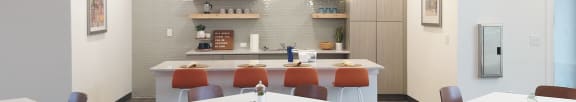 Foote Park at South City community room kitchenette with orange bar stools and gray cabinets with open concept shelving