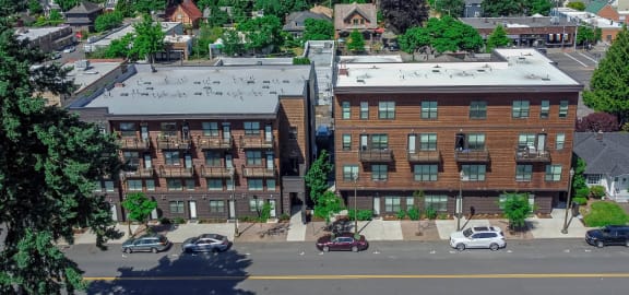a rendering of a three story apartment building with wood siding and balconies