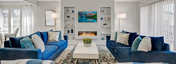 a living room with blue couches and a fireplace