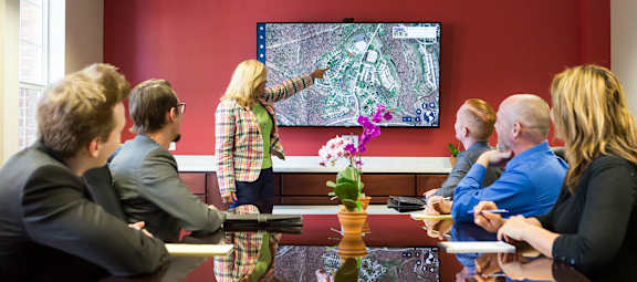 A group of people are gathered around a table playing a video game.