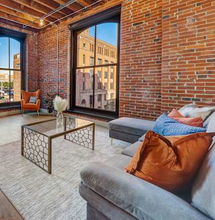 a living room with a couch and a large window at Greeley Lofts, Missouri
