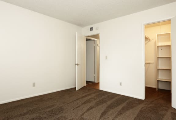 A room with a striped carpet and a white door.