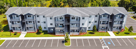 a rendering of an apartment complex with cars parked in front of it at Gibson Oaks, Lakeland, FL