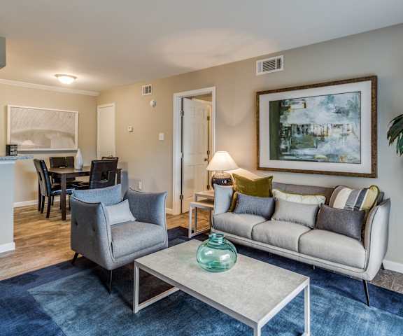 a living room with a couch and two chairs and a table