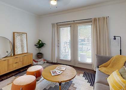 a living room with a couch and a mirror and a window