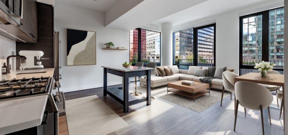a living area with a kitchen and a living room with a couch and a table