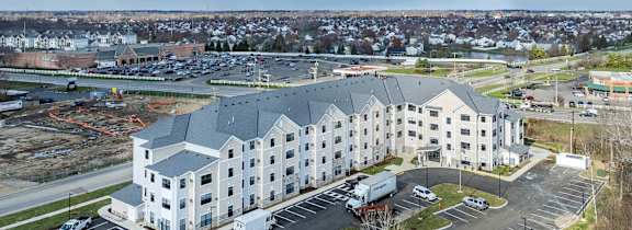 A large building with a parking lot in front.