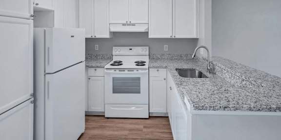 a kitchen with a white refrigerator freezer next to a stove top oven