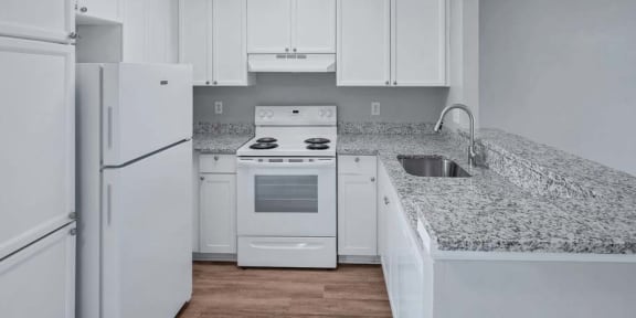 a kitchen with a white refrigerator freezer next to a stove top oven
