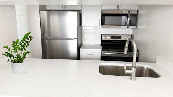 A kitchen with a stainless steel refrigerator, microwave, oven, and dishwasher.