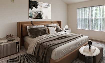 A bedroom with a large bed and a small table.