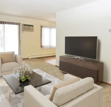 a living room with white furniture and a flat screen tv