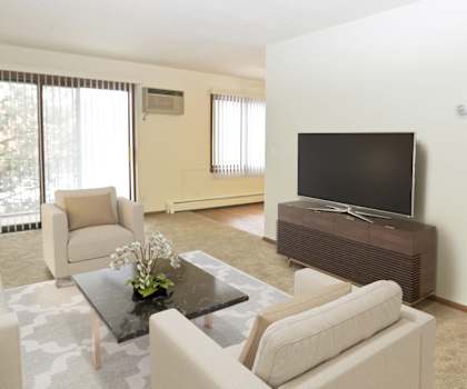 a living room with white furniture and a flat screen tv