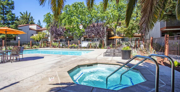 our apartments have a swimming pool and a patio with chairs and umbrellas at Valley Plaza Villages, Pleasanton, 94566