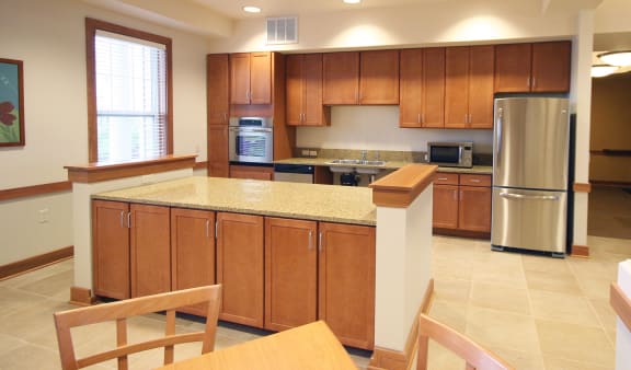 a large kitchen with wooden cabinets and a counter top at Senior Living at Cambridge Heights